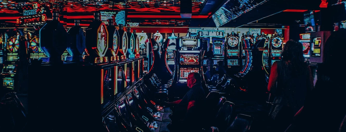 Mand der spiller på spilleautomater i en casino arkade
